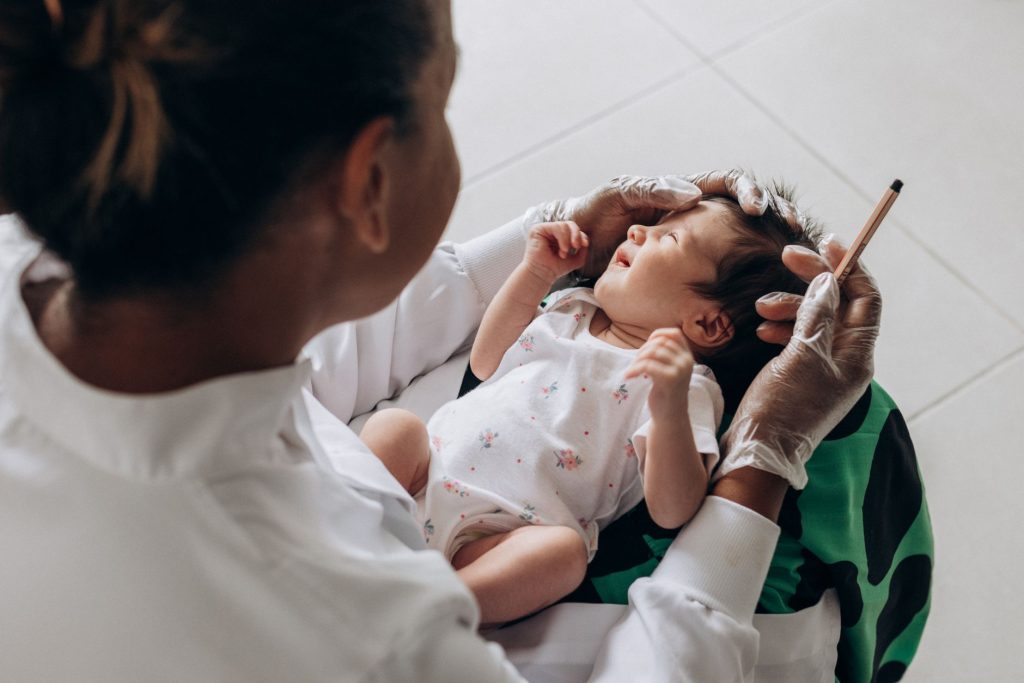 Healthcare professional examining an infant baby during a checkup